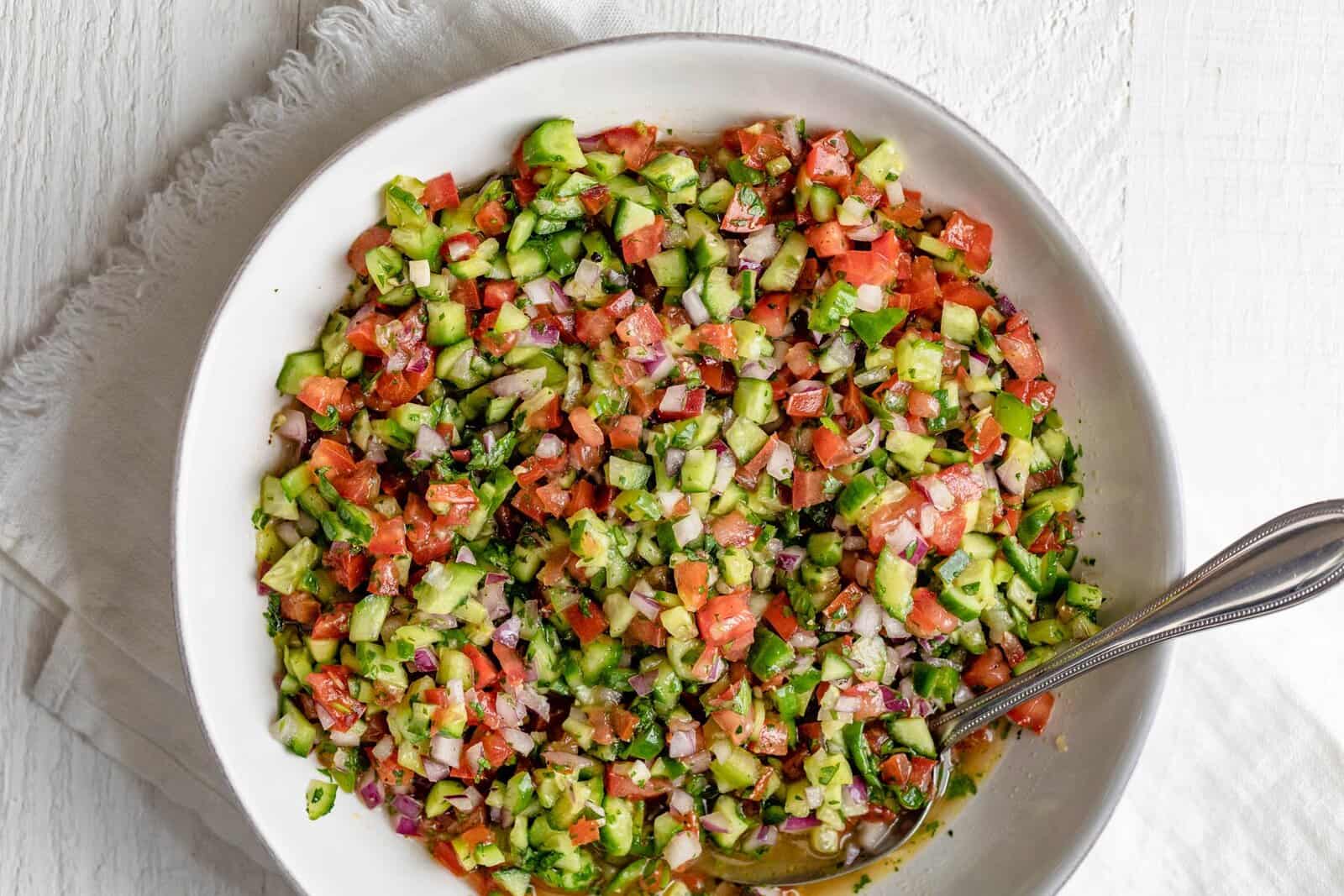 Shirazi salad in a serving bowl with a spoon. 