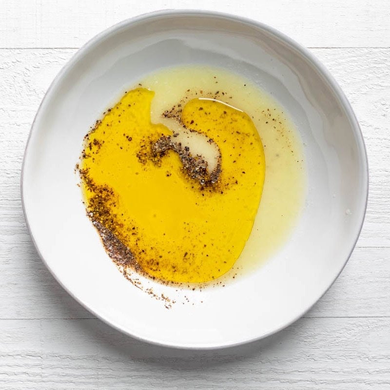 Dressing ingredients in a bowl before combining.