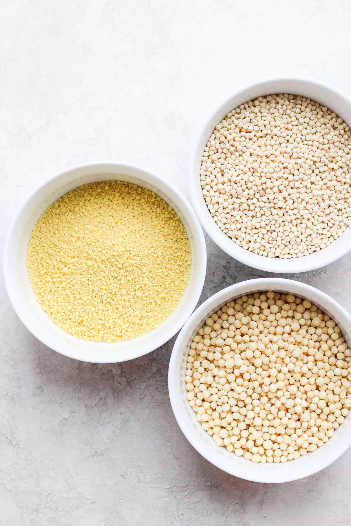 Three types of couscous in bowls before cooking