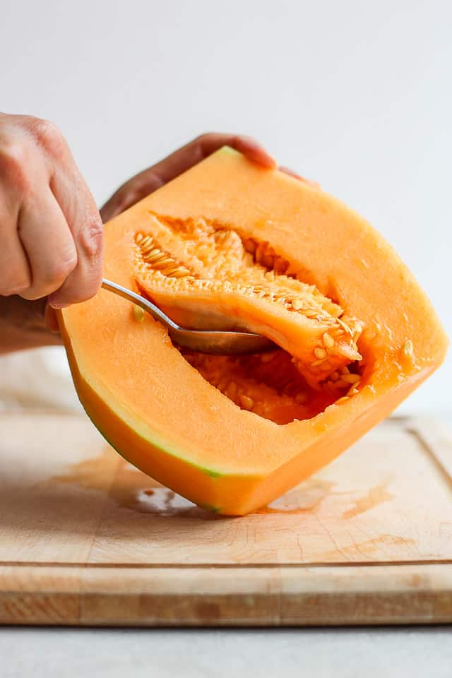 Removing seeds from cantaloup with spoon