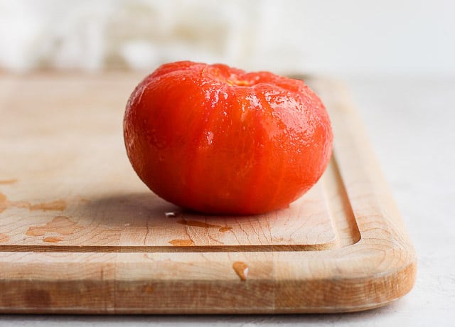 Peeled large tomato on cutting board