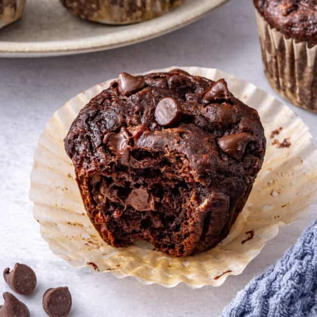 Close shot of one muffin with a bite taken.
