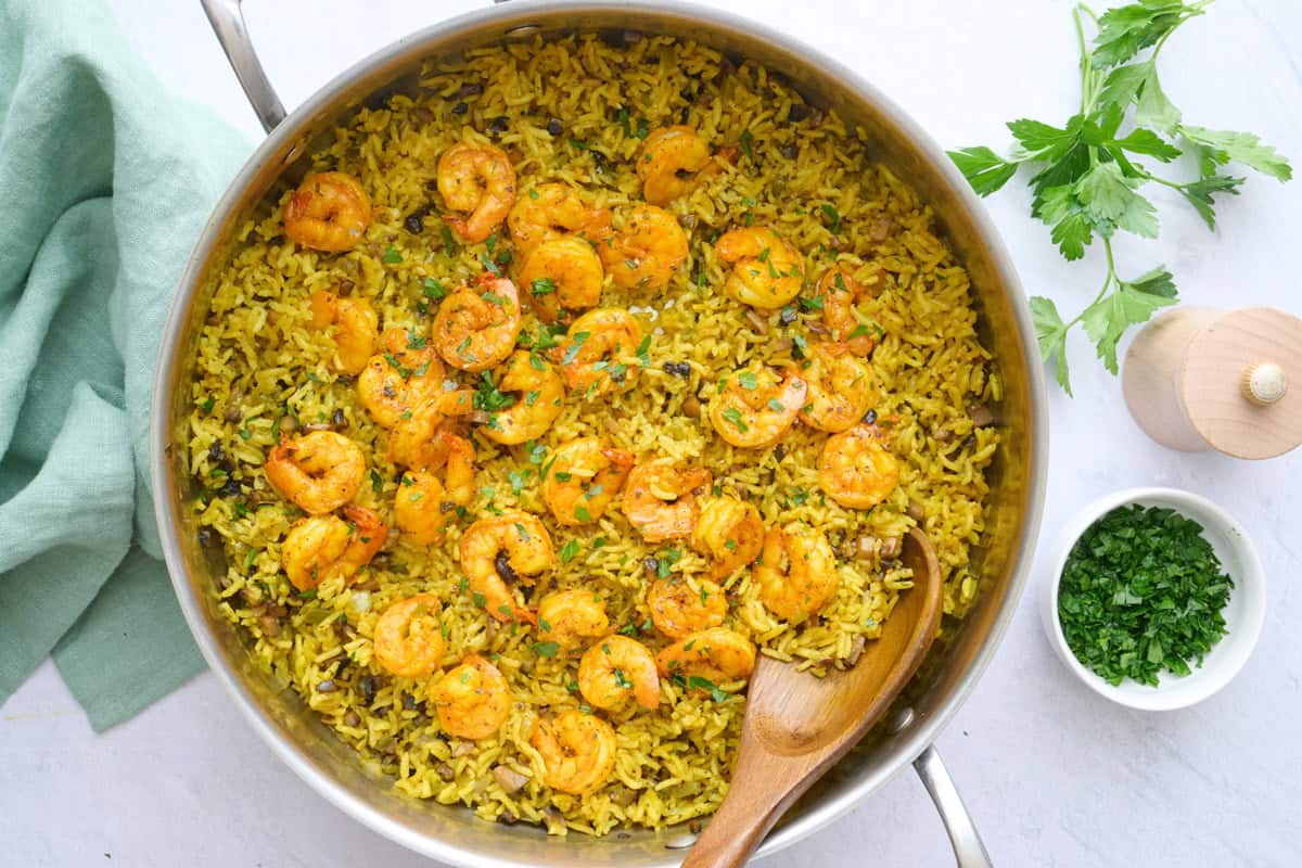 Shrimp and rice in the pot after fluffing rice, garnished with chopped parsley.