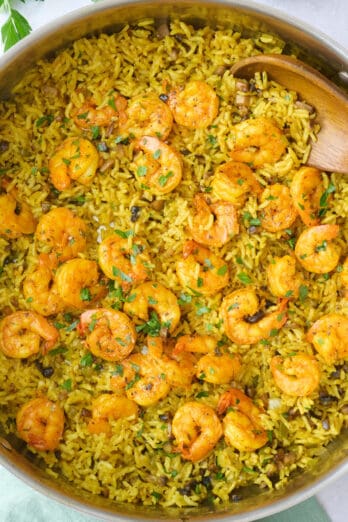 Shrimp and rice in the pot after fluffing rice, garnished with chopped parsley.