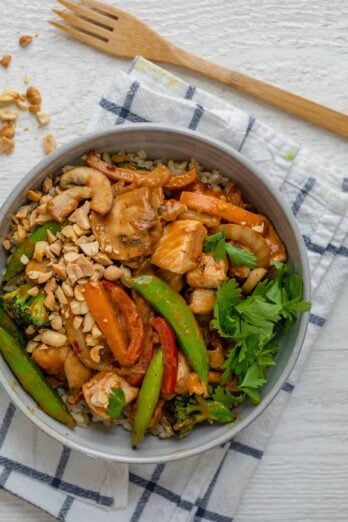 Thai peanut chicken stir fry serve in a bowl with brown rice