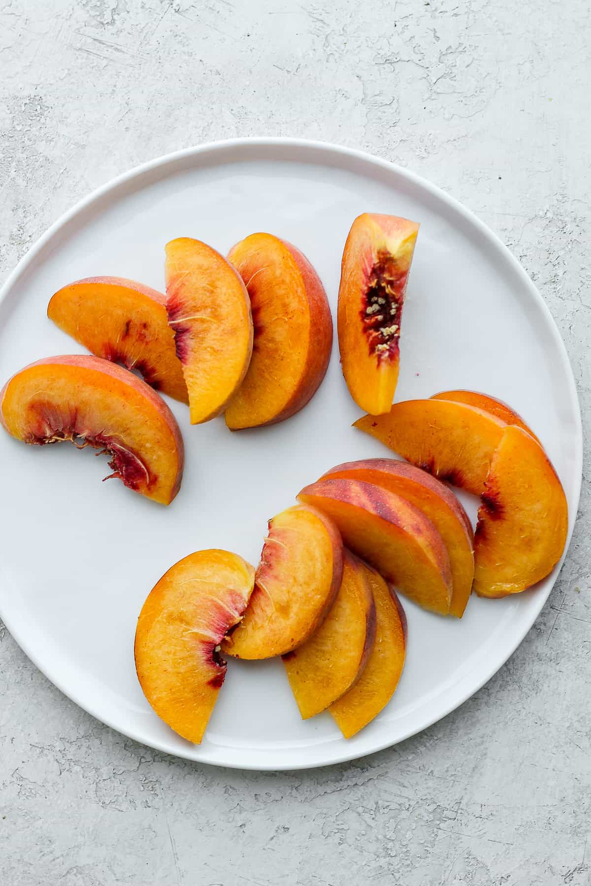 Sliced peaches on white plate