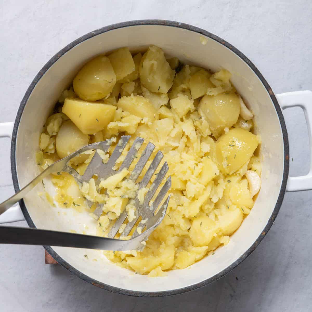 With olive oil and thyme on top, show mashing.