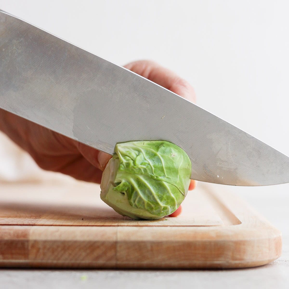 Brussel sprout length-wise on the cutting board.