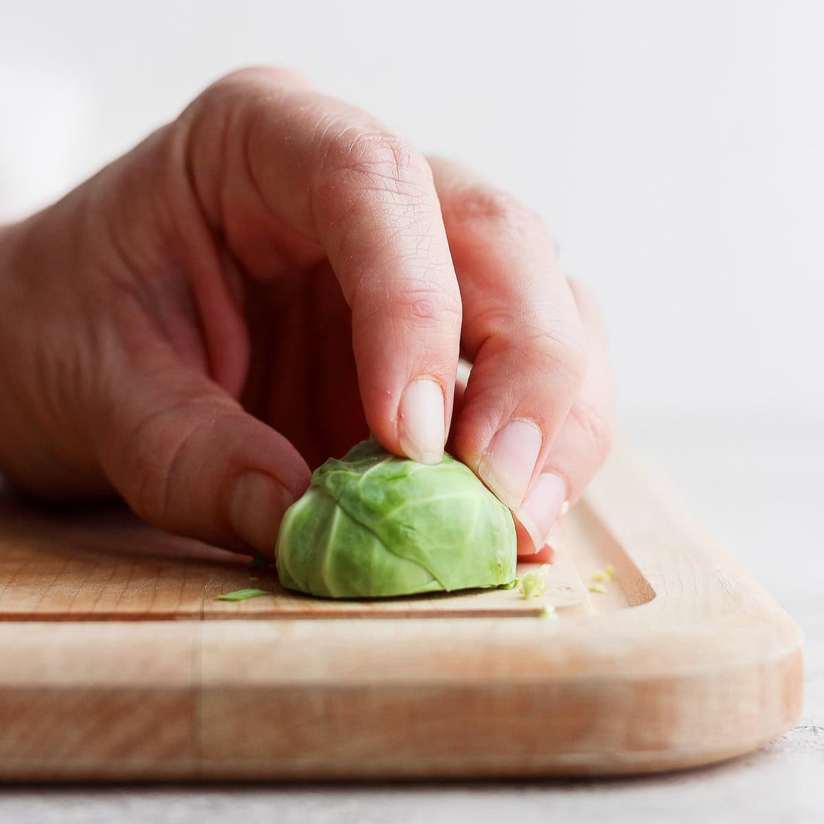 Brussel sprout in half placed cut side on the cutting board.