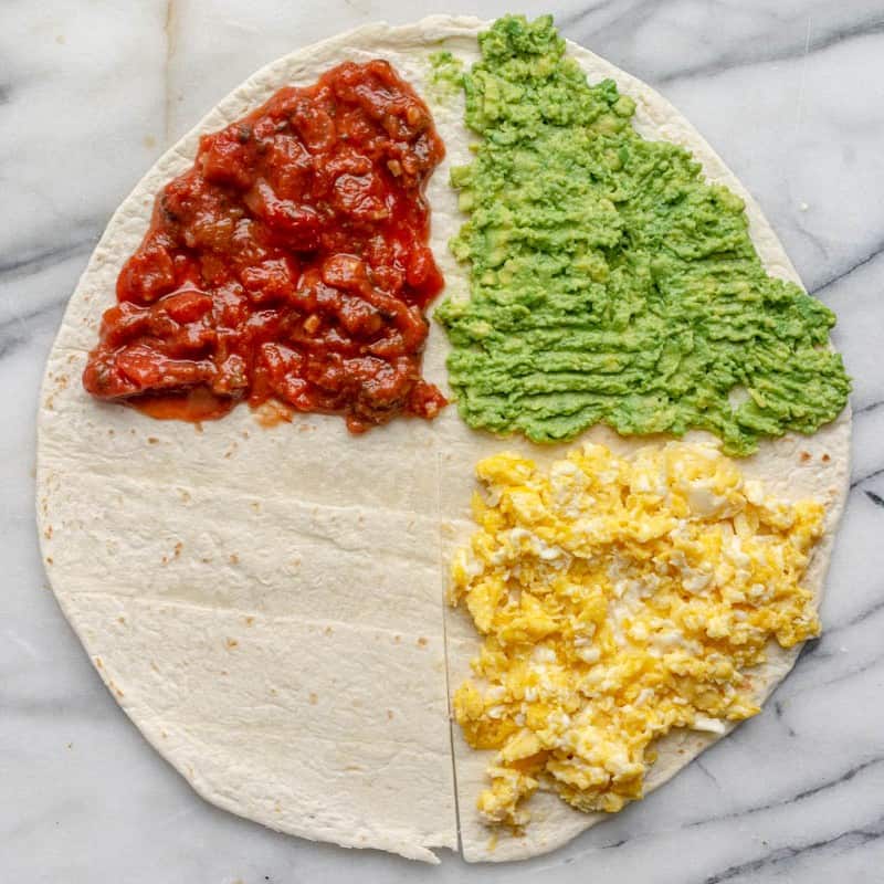 Tortilla with eggs on 1/4, avocado on 1/4, and salsa on 1/4.