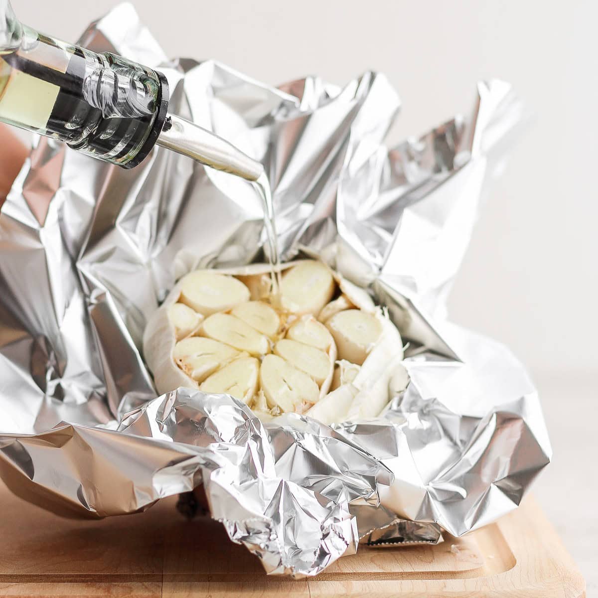 Drizzling oil on the garlic.