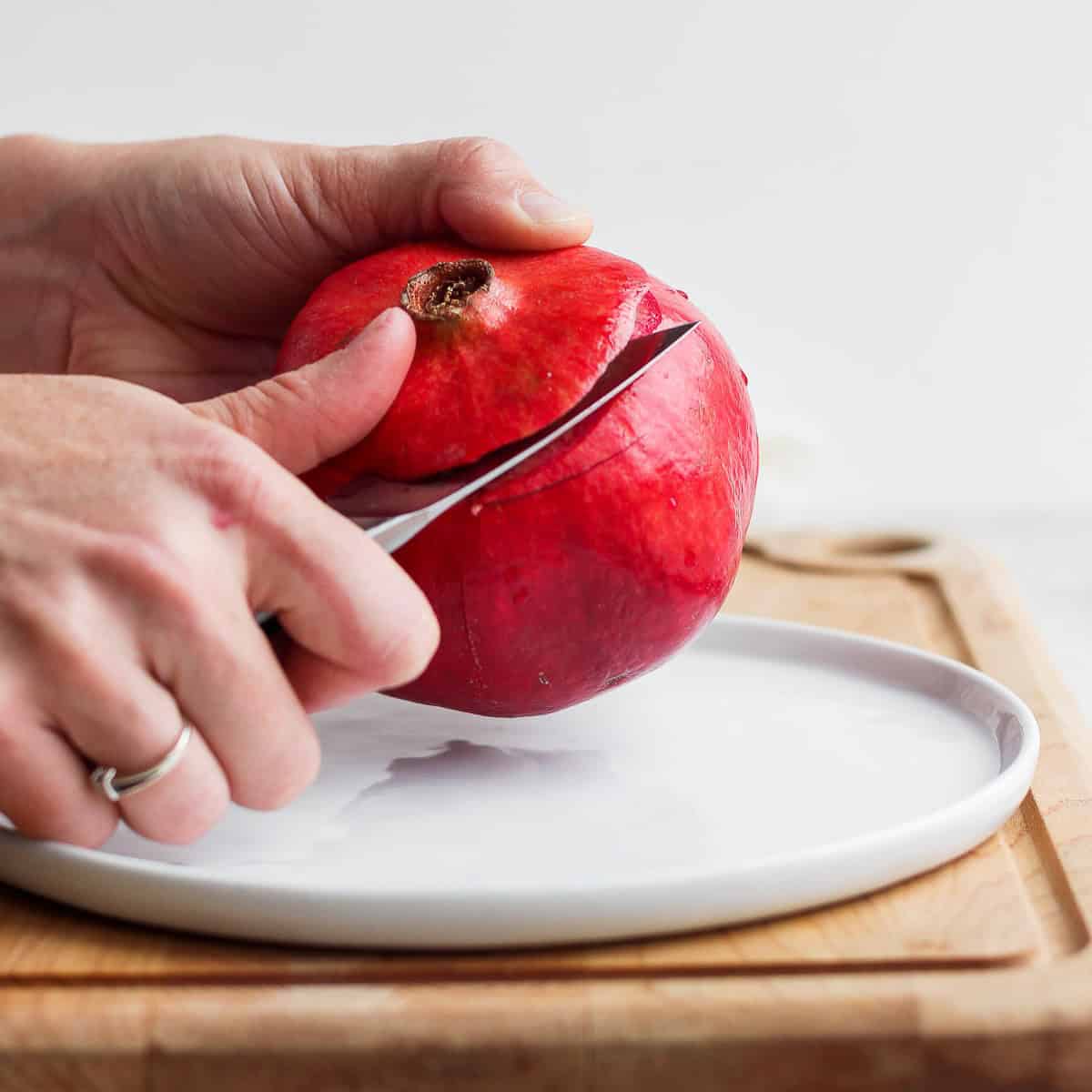 Slicing the top of the pomegranate off.