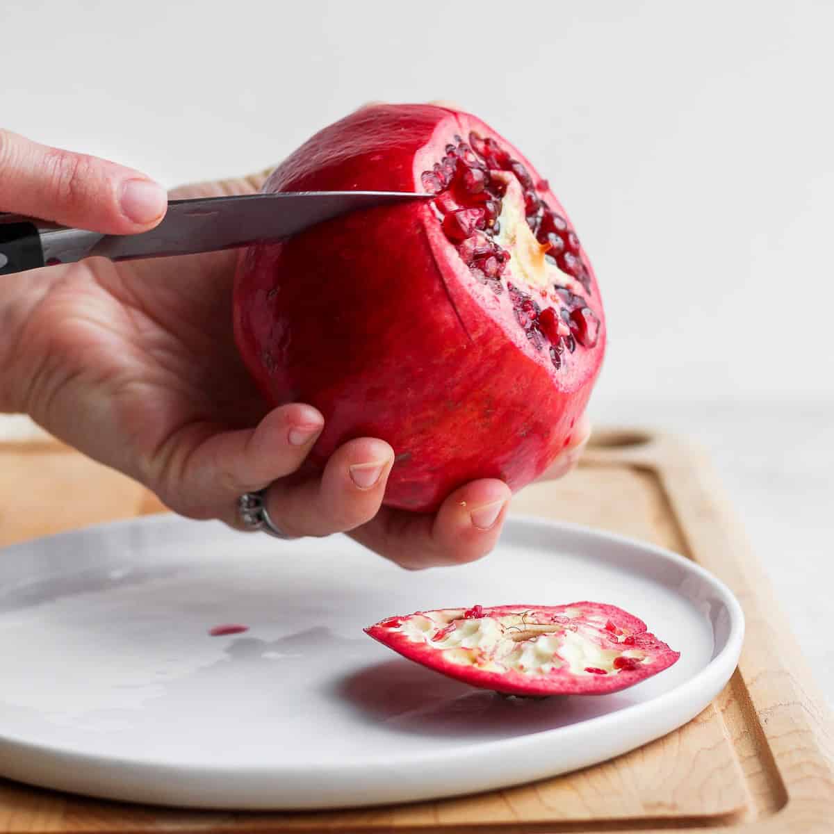 Slicing the side of the pomegranate.