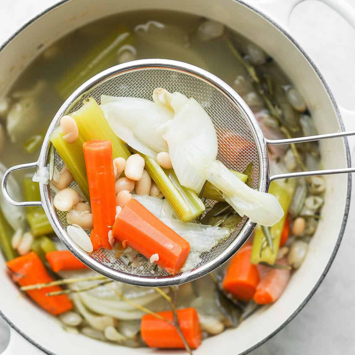 Removing the vegetables from the pot.