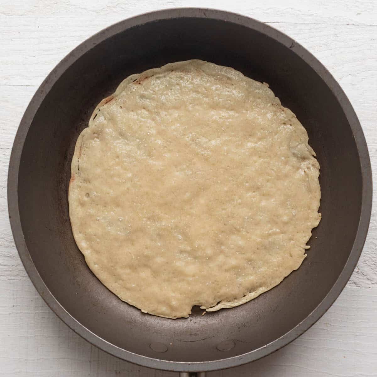 After cooking one side of the crepe.