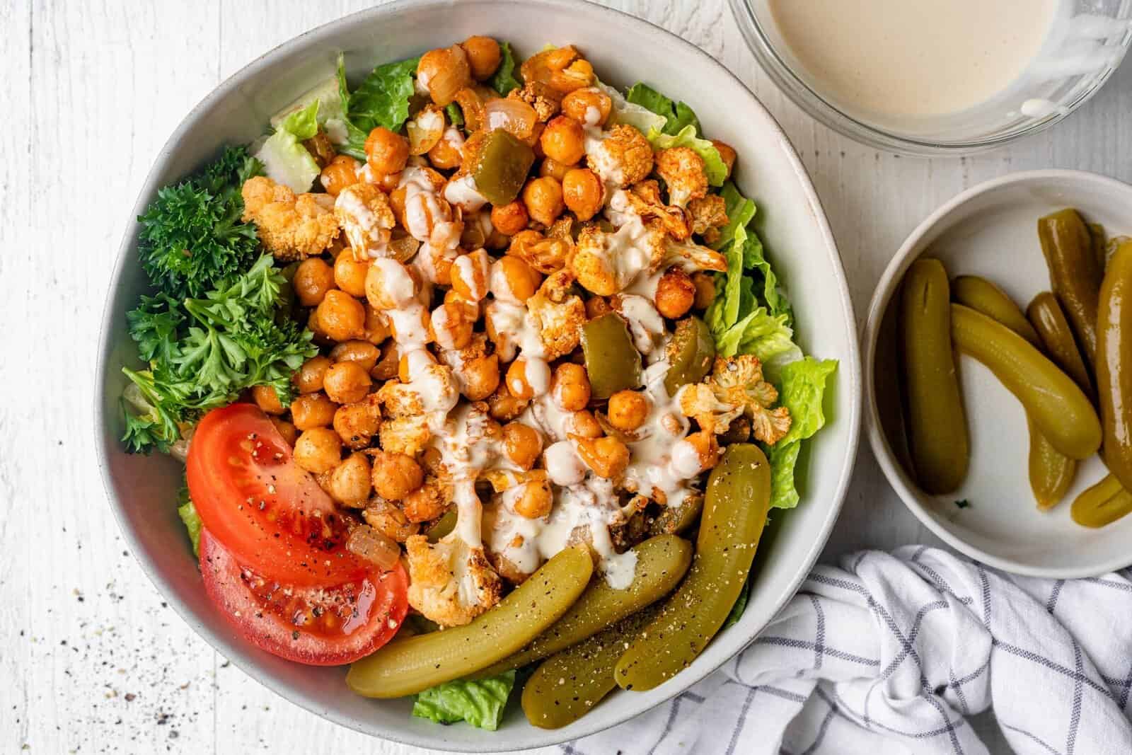 Oven roasted chickpea shawarma in a bowl with toppings surrounding. 