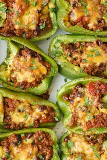 Taco stuffed bell peppers in the baking dish garnished with chopped cilantro,