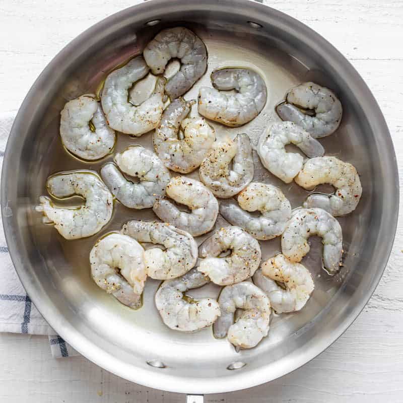 Uncooked shrimp in pan.