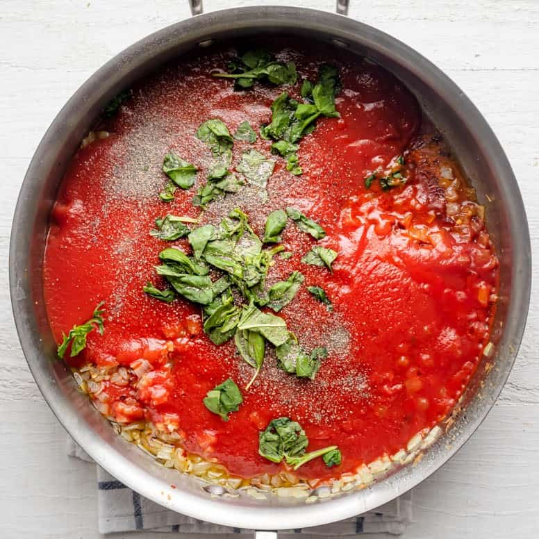 Sauce and basil added on top of the garlic.