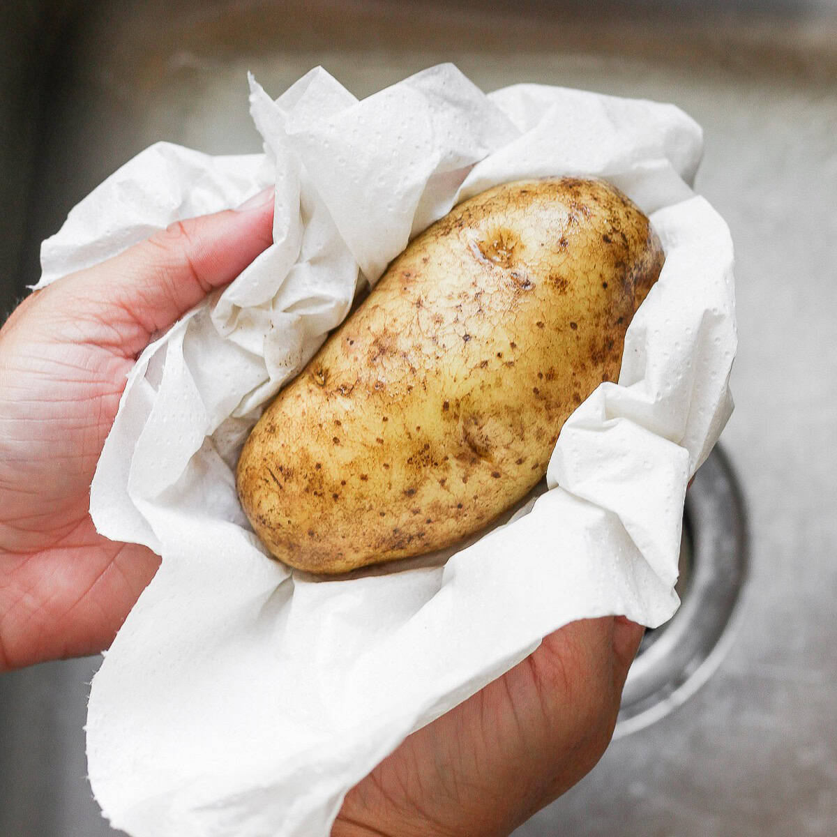 Drying off potato with a towel.
