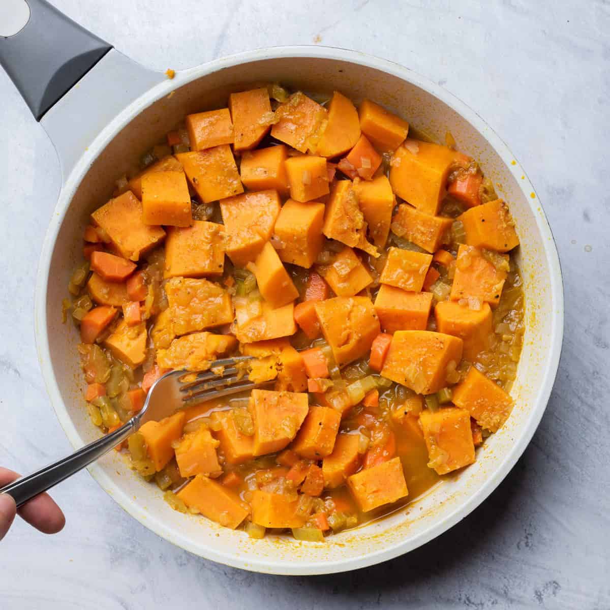 Sweet potatoes tender with fork in pot.