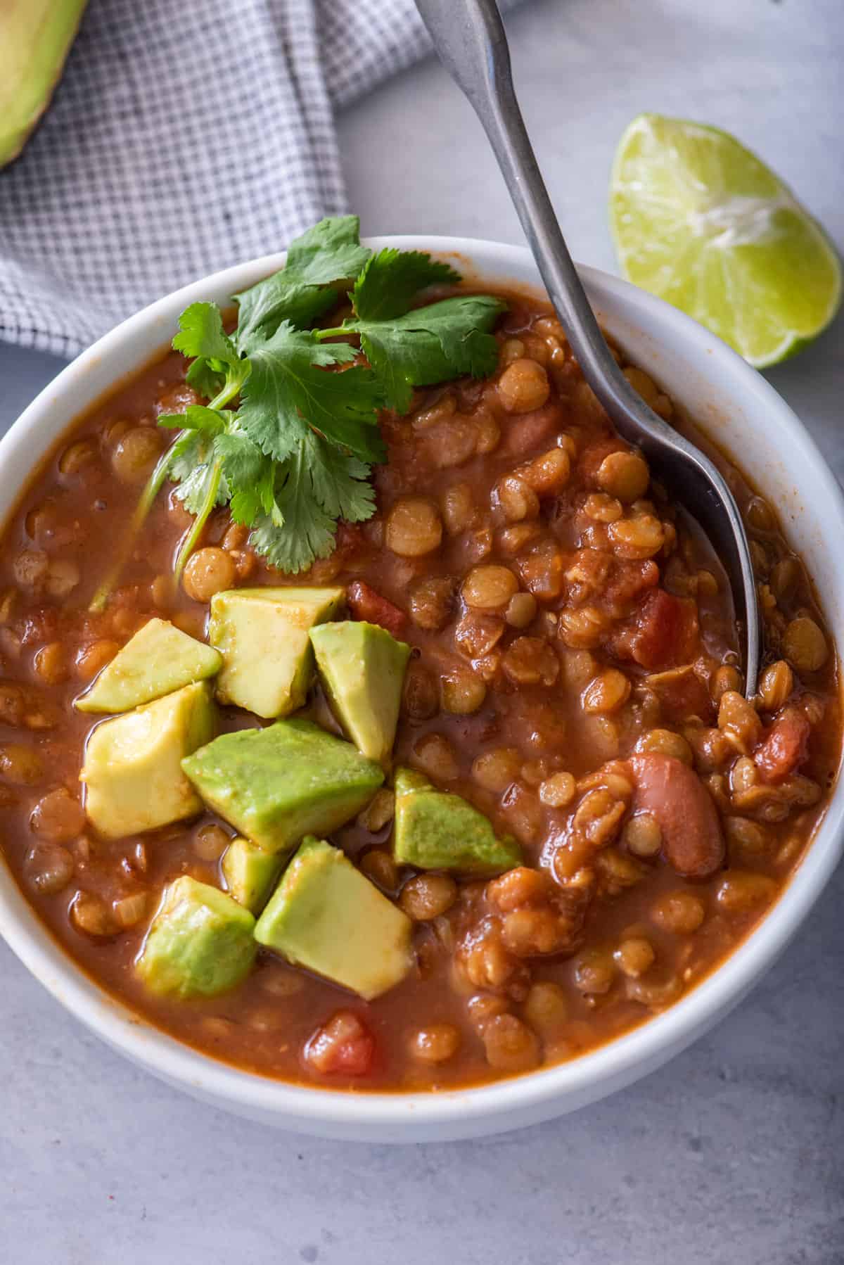 Vegan lentil chili made in the instant pot topped with avocado and cilantro