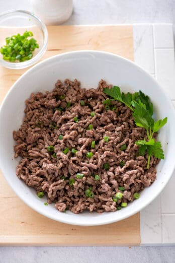 Cooked ground beef from instant pot in bowl with parsley