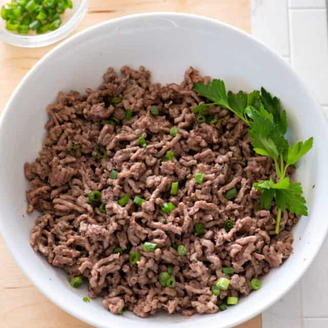 Cooked ground beef from instant pot in bowl with parsley