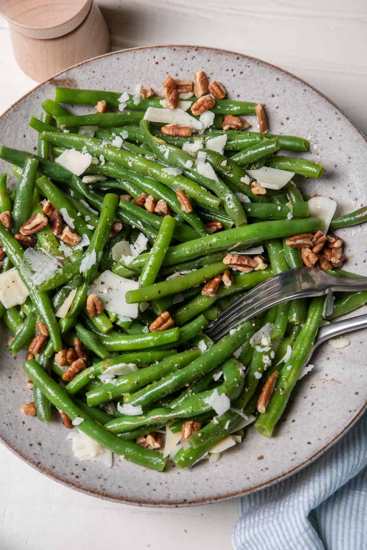 Large bowl of green bean salad with parmesan cheese and pecans