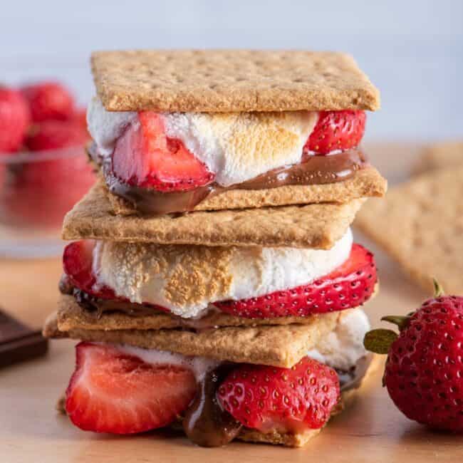 Stack of sโmores with ingredients nearby.