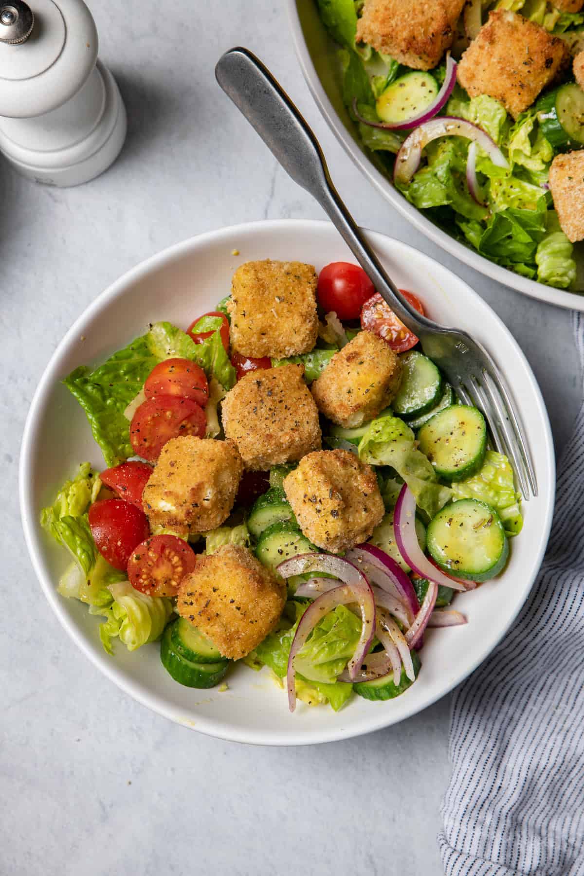 Small bowl of crispy feta croutons on top of salad