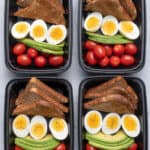 4 meal prep containers with the avocado, egg, toast and tomatoes