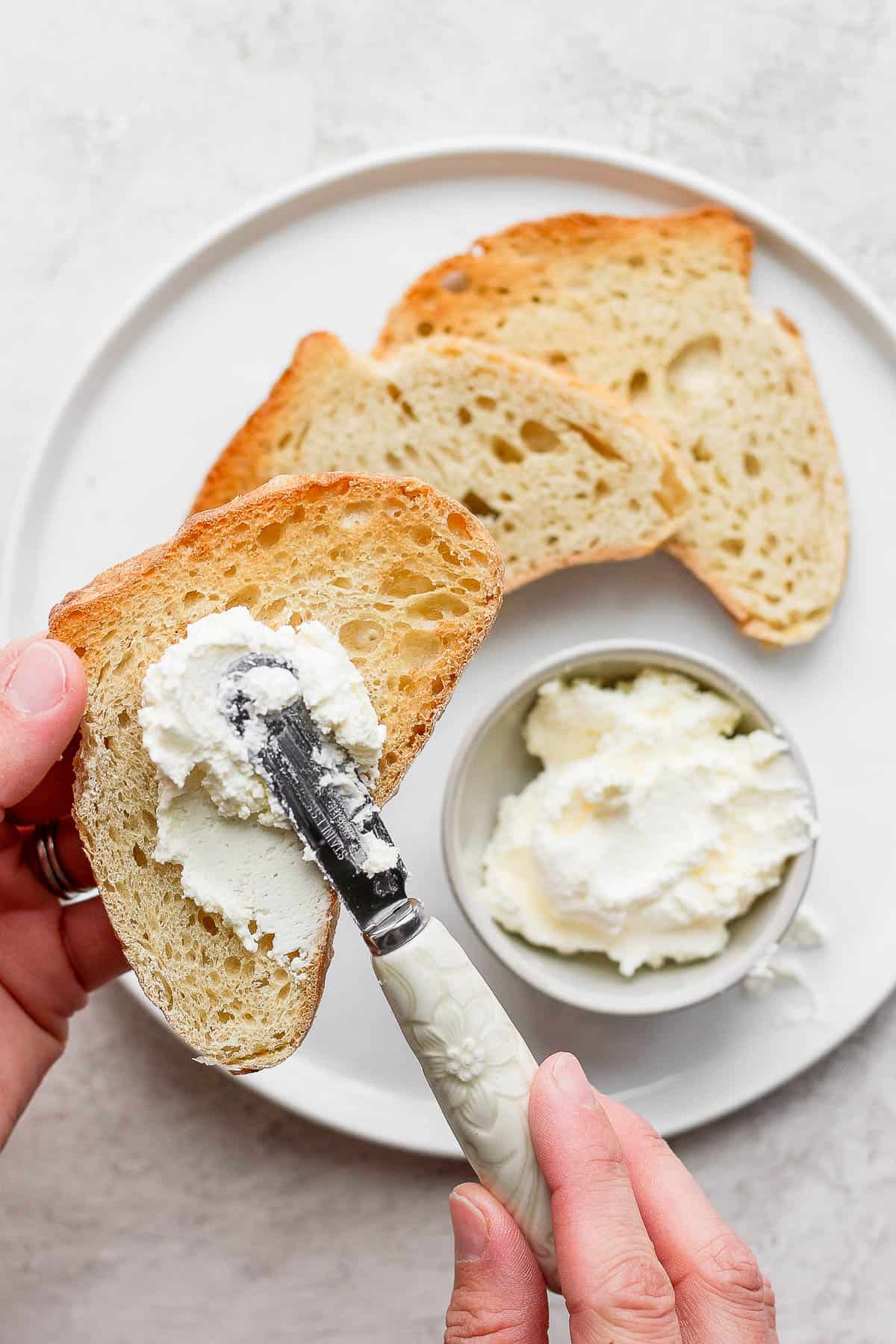 Spreading homemade butter on sourdough toast