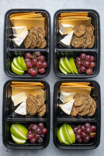 Meal prep containers with cheese, fruit and crackers