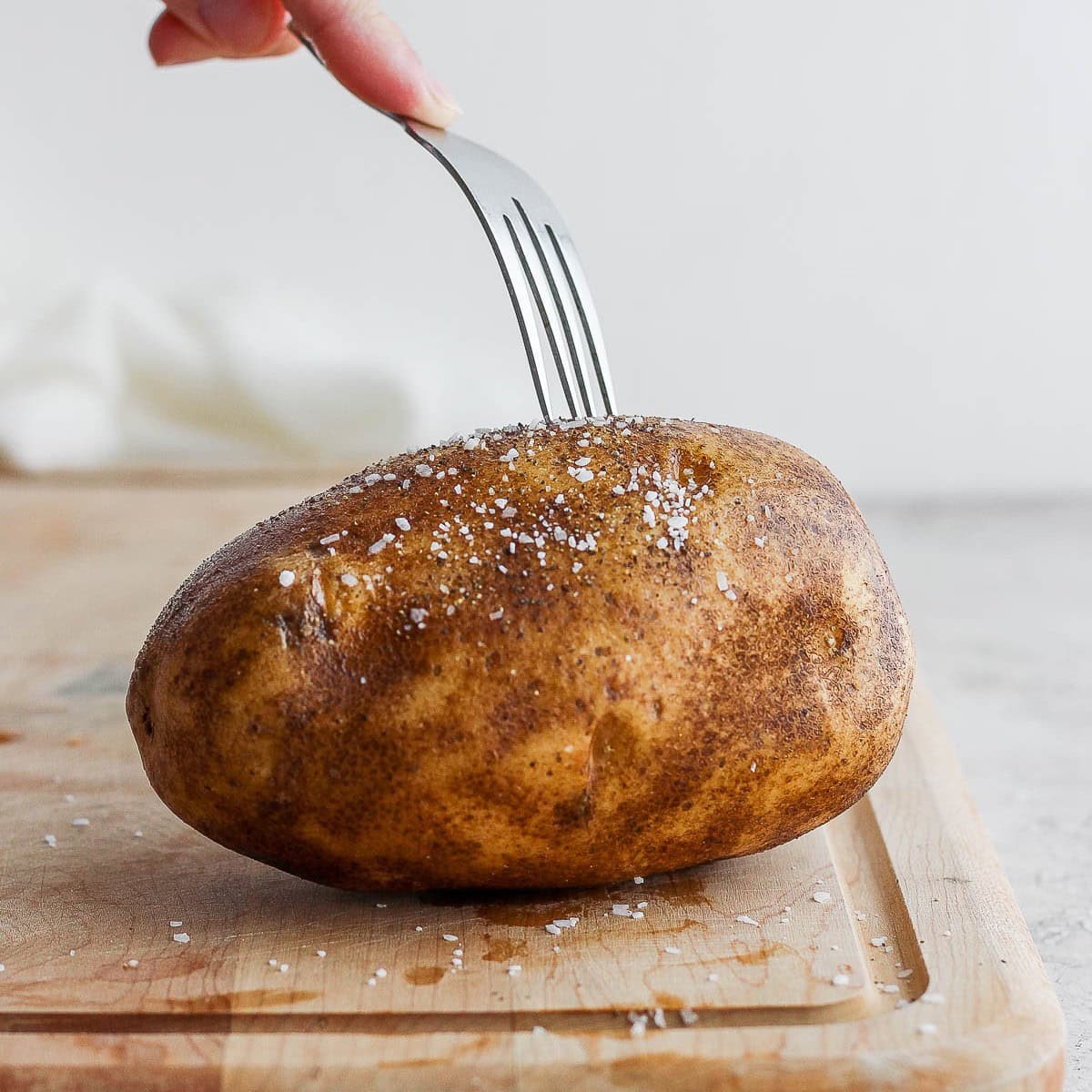 Poking holes in potato with fork.