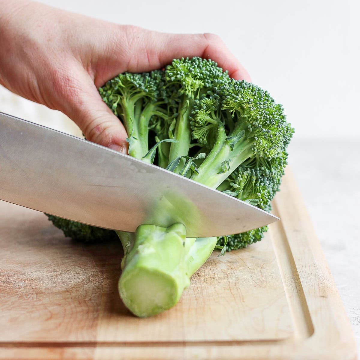 Cutting a few inches off the end of the broccoli stalk.