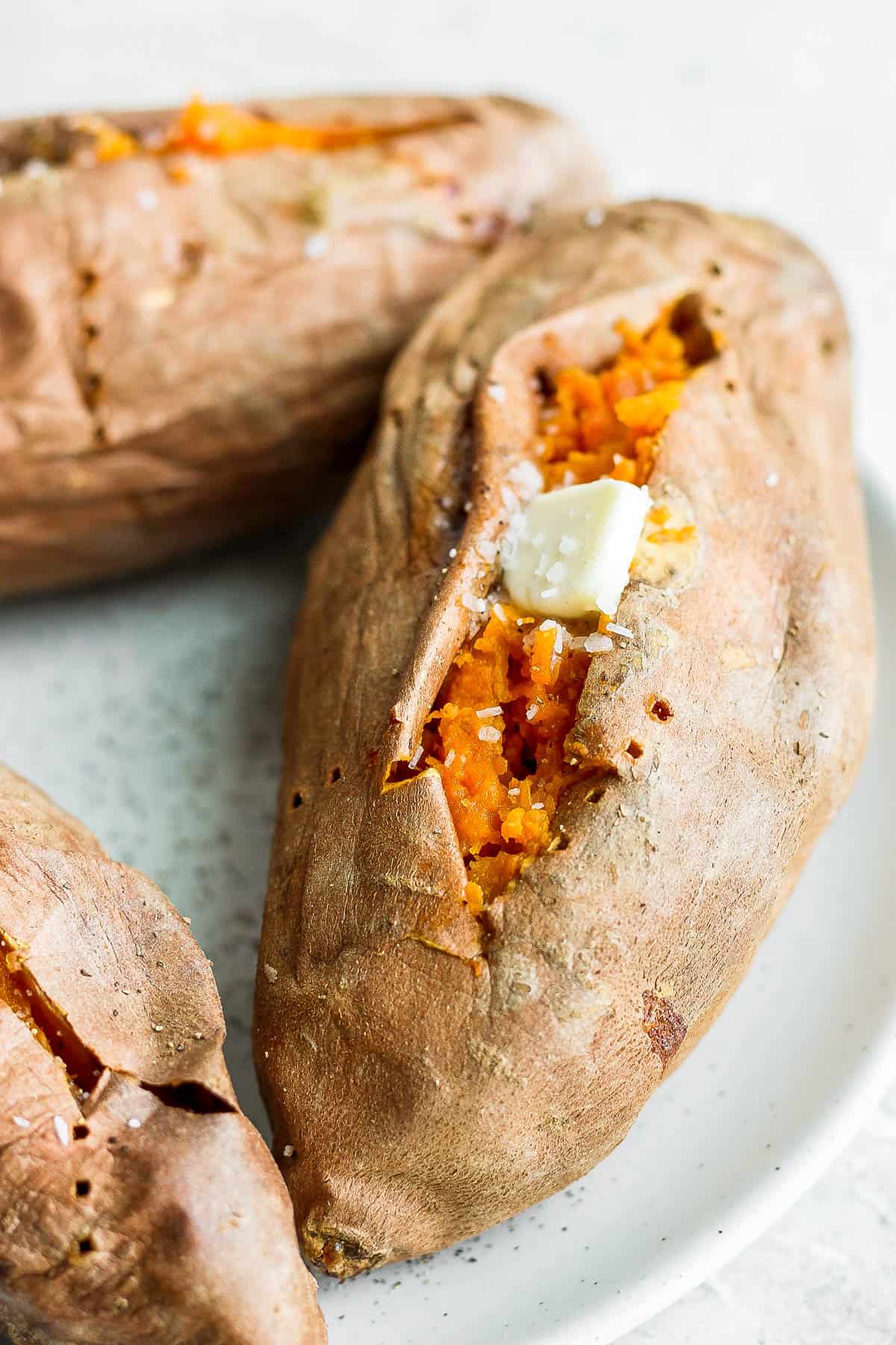 Close up shot of sweet potatoes after baking with dab of butter