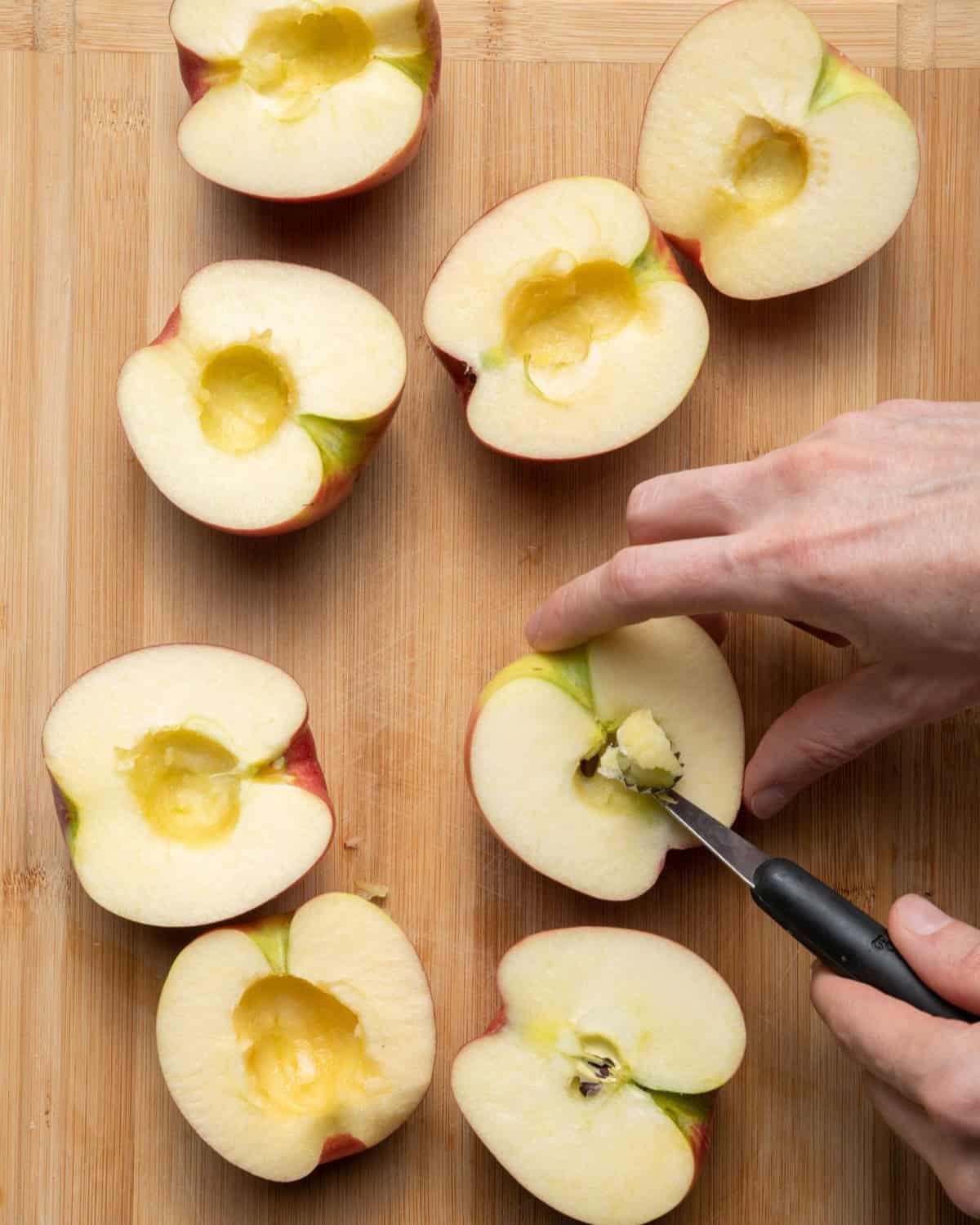 Using melon baller to scoop out the core of the apples.