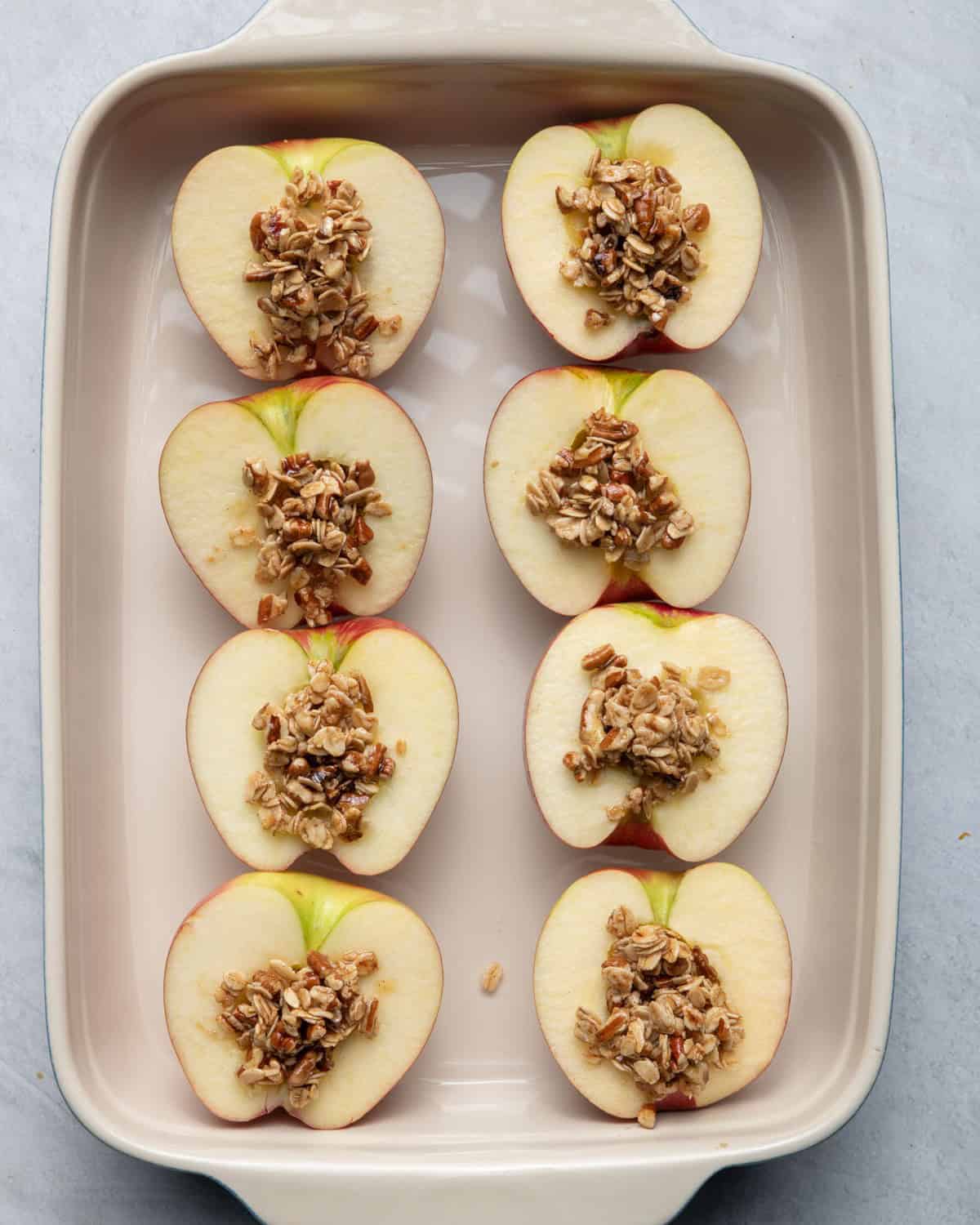 4 apples in baking dish with stuffing inside before baking.