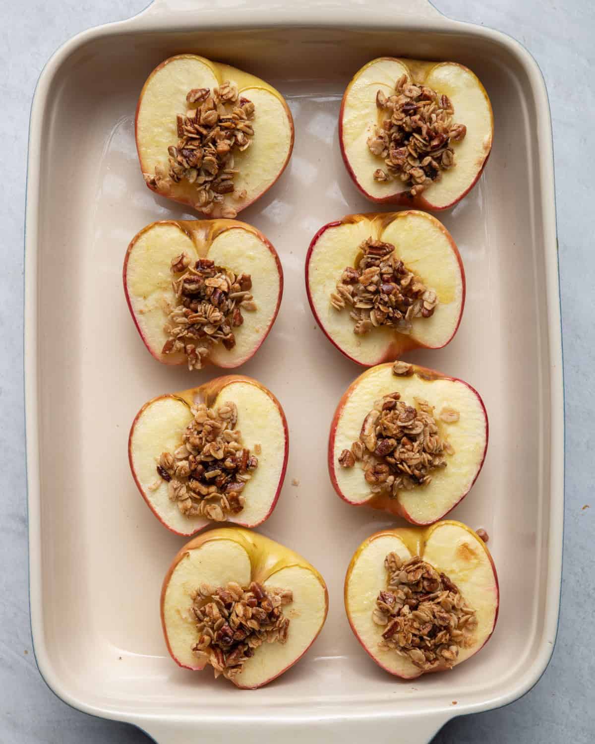4 apples in baking dish with stuffing inside after baking.
