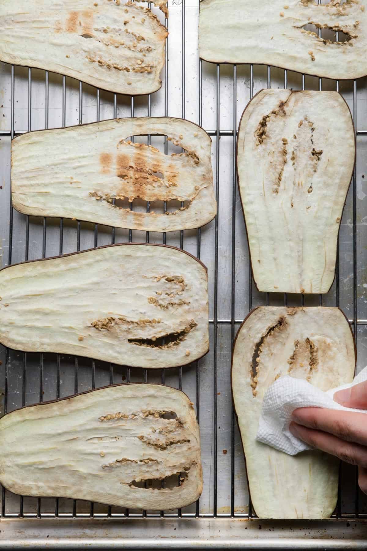 Dabbing eggplant dry with paper towel.
