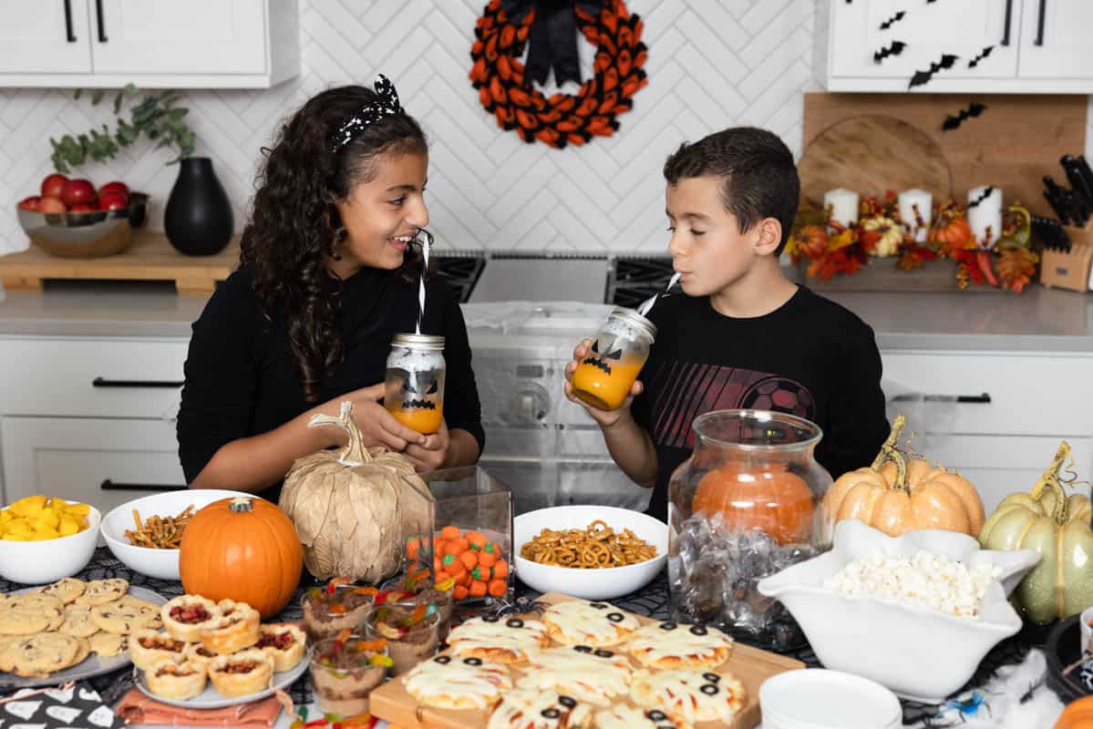 Kids drinking orange juice from monster mason jars