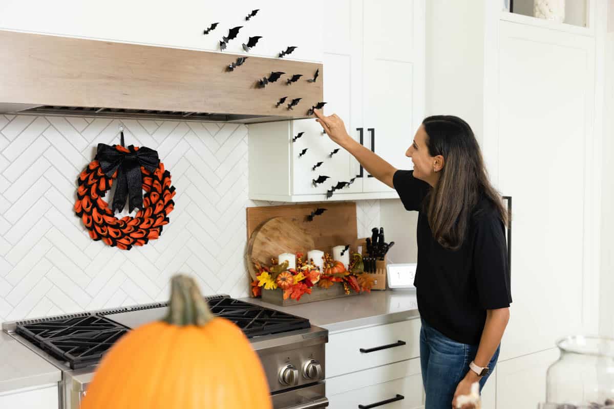 Yumna setting up bats decor in kitchen for Halloween