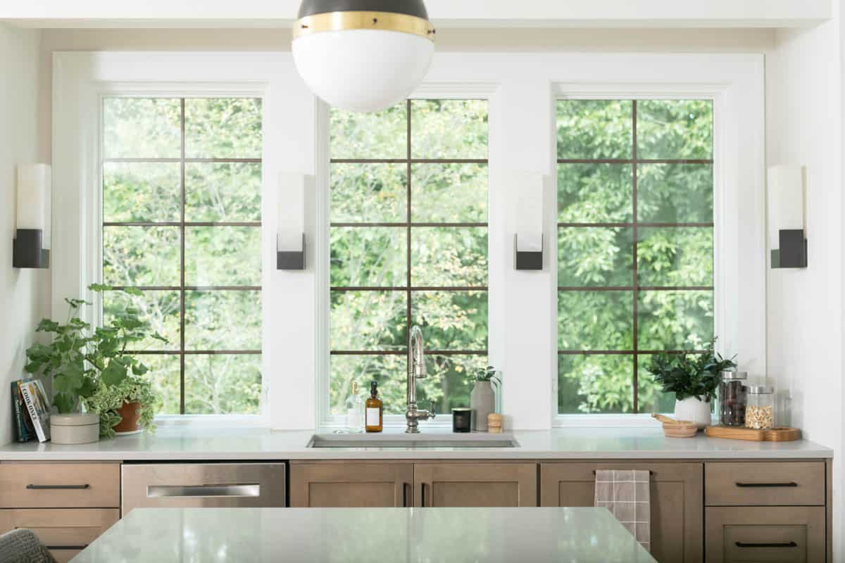 View of the counter space with the sink, garbage and dishwasher overlooking the backyard