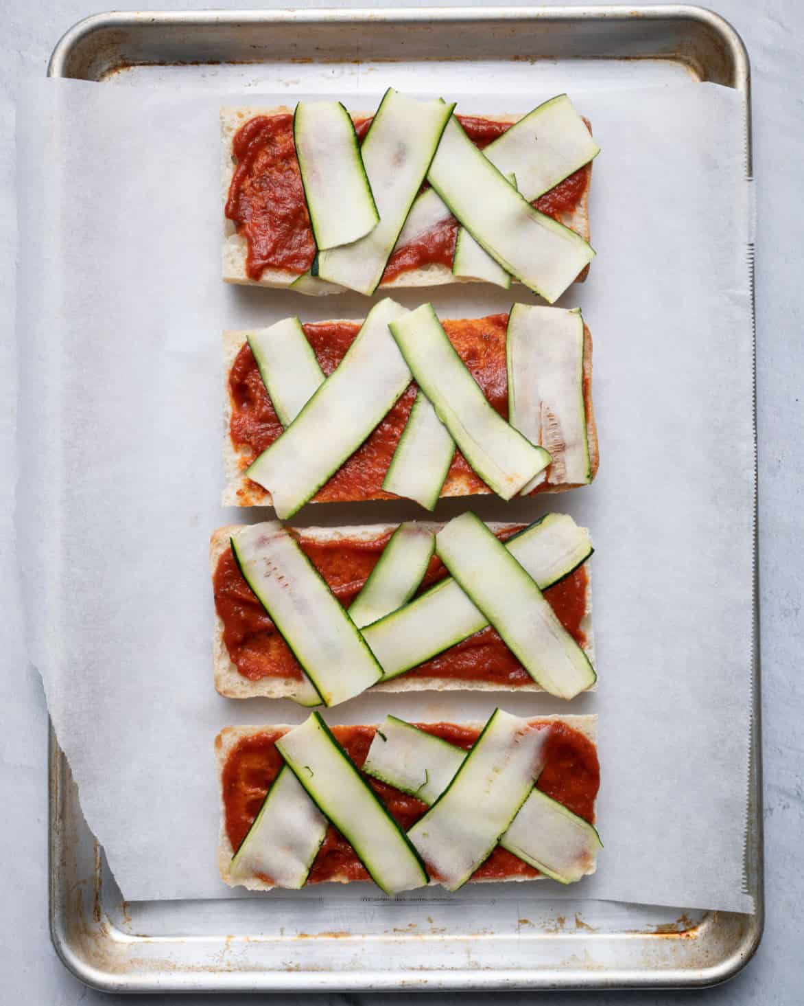 Zucchini on top, tucked under the bread.