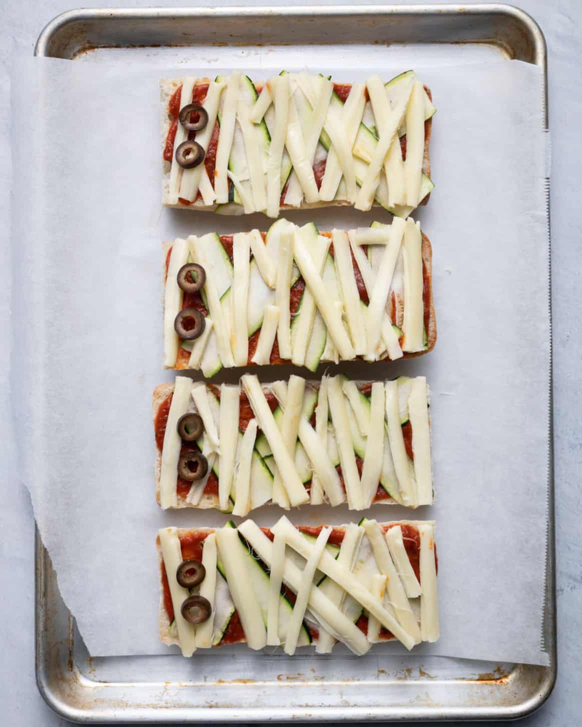 String cheese on top with olives added as eyes.