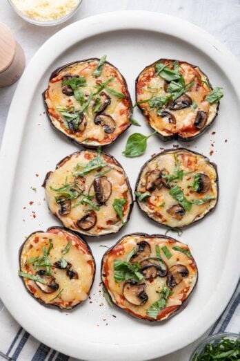 Large platter of eggplant pizza topped with mushrooms