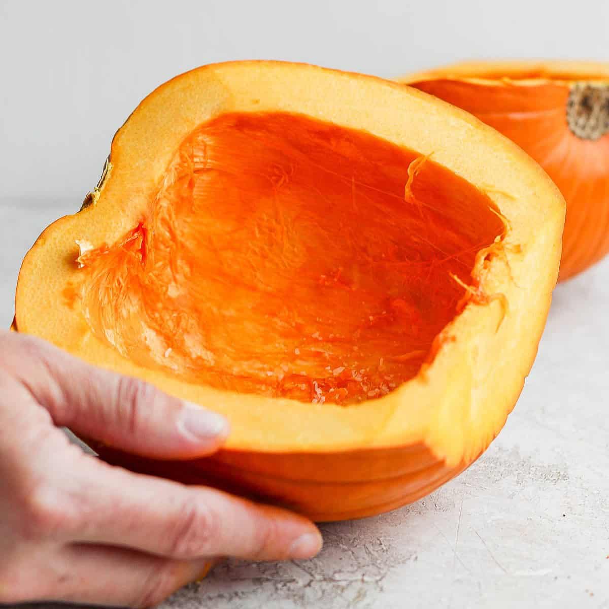 Add olive oil or salt/pepper on flesh of pumpkin halves.