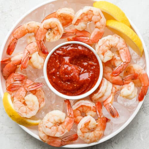 Shrimp cocktail served with the sauce over bed of ice with lemon wedges
