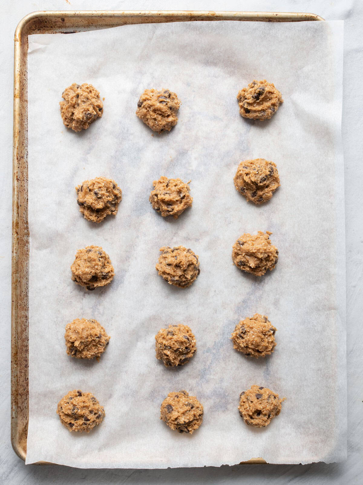 Baking sheet with 12 cookie dough balls before baking.